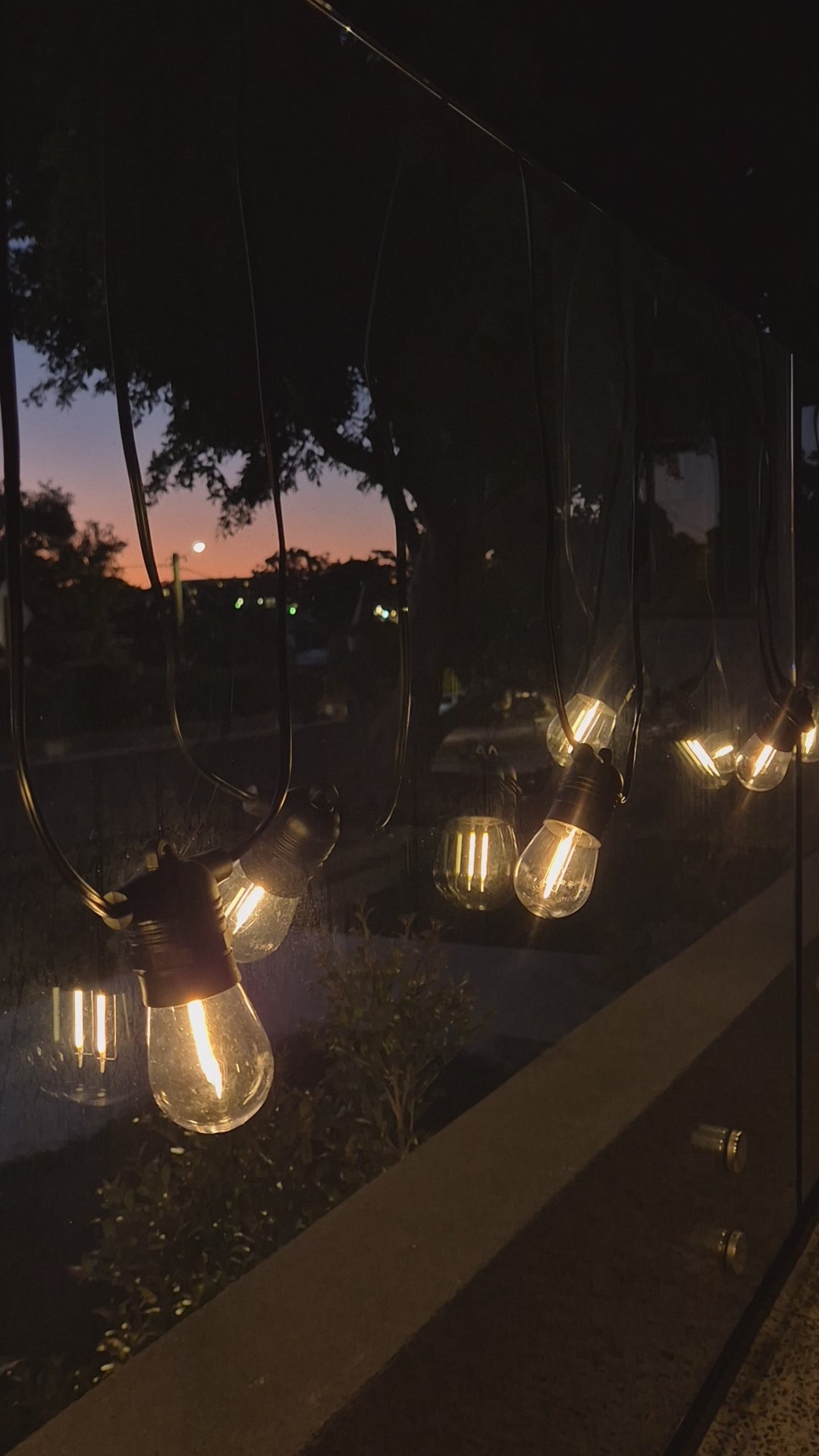Solar festoon lights glowing at night creating warm ambient backyard garden lighting