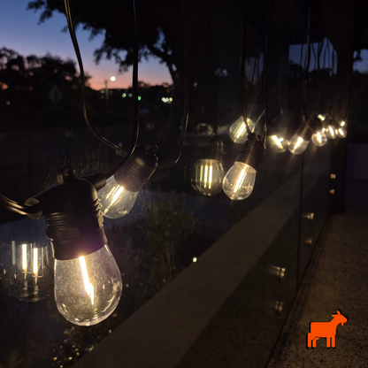 Solar garden festoon lights installed across outdoor patio and pergola during daytime